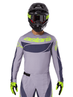 Alpinestars Techstar Dreem 2025, ensemble maillot et équipement de motocross, gris clair et gris foncé avec accents jaune fluo, logo 'astars', avec casque noir, lunettes et gants assortis, matériau technique perforé pour la performance tout-terrain
