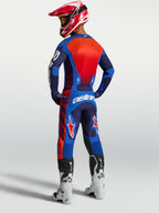 Alpinestars Maillot Racer Hunt, maillot de motocross pour homme, bleu et rouge, poly-tissu respirant, vue de dos sur un pilote