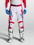 Alpinestars Pantalons Racer Hunt, pantalons de motocross homme, blancs, rouges et bleus, jambes pré-courbées ergonomiques, panneaux de genoux en cuir, portés avec bottes et gants assortis