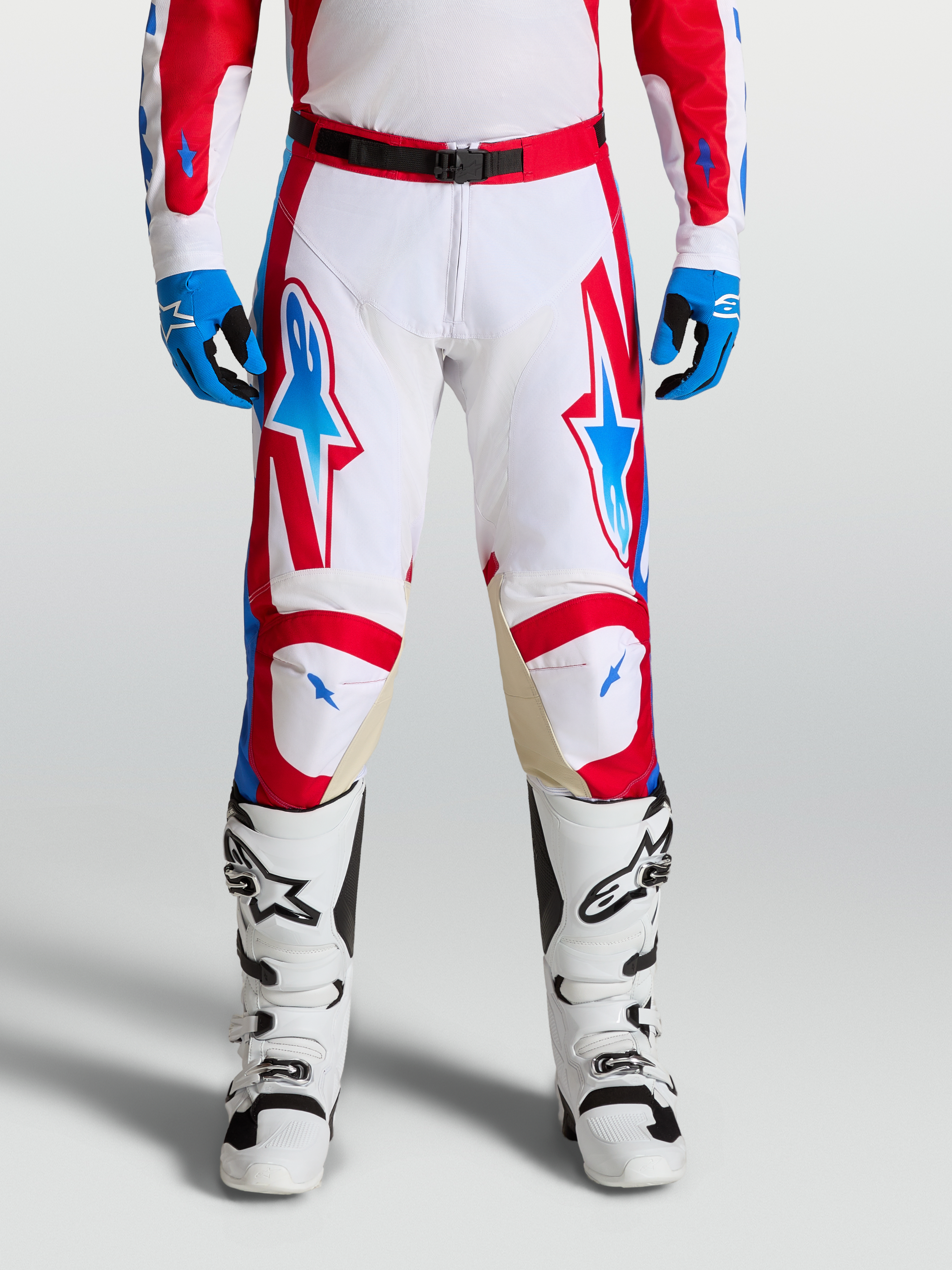 Alpinestars Racer Hunt Pants, performance motocross racing pants in white, fire red, and blue with ergonomic pre-curved legs and leather knee panels.