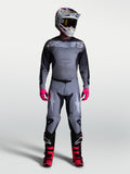 Alpinestars Racer Amber Gear Set 2027, tenue de motocross grise et noire aux accents rose vif, portée par un mannequin.