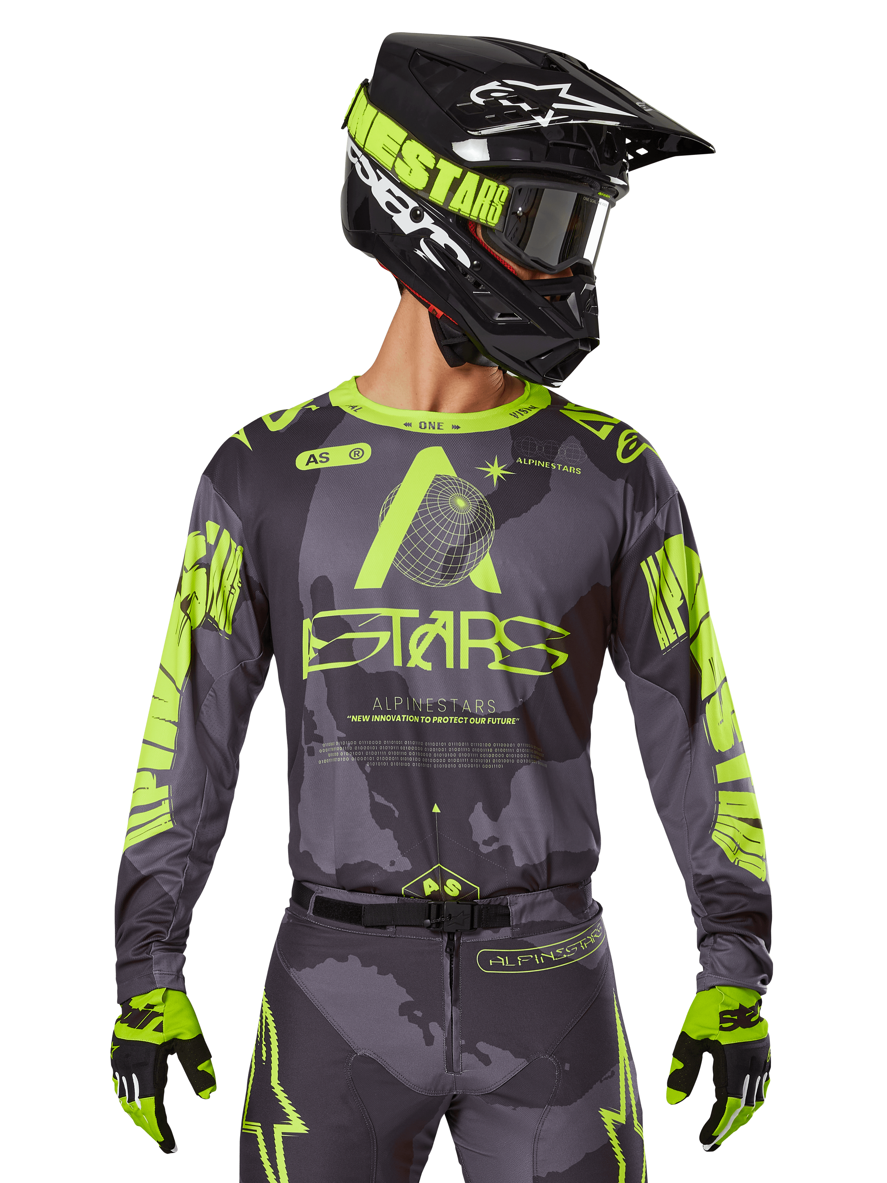 Maillot Alpinestars 2025 Racer Hollow, maillot de motocross, camouflage sombre et jaune fluo, porté avec pantalon assorti, casque noir et jaune avec masque et gants noirs, avec logo Alpinestars et motif camouflage