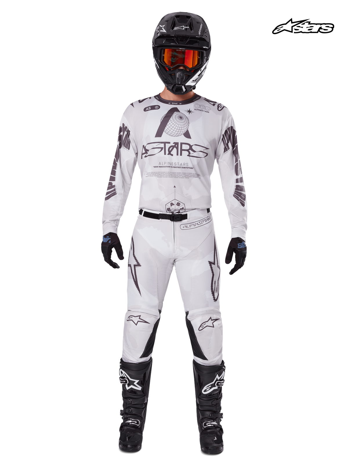 Tenue Complète Racer Hollow 2025 d'Alpinestars, maillot et pantalon de motocross pour homme en blanc et marron clair, vue studio de face sur un modèle portant un casque, des gants et des bottes assortis