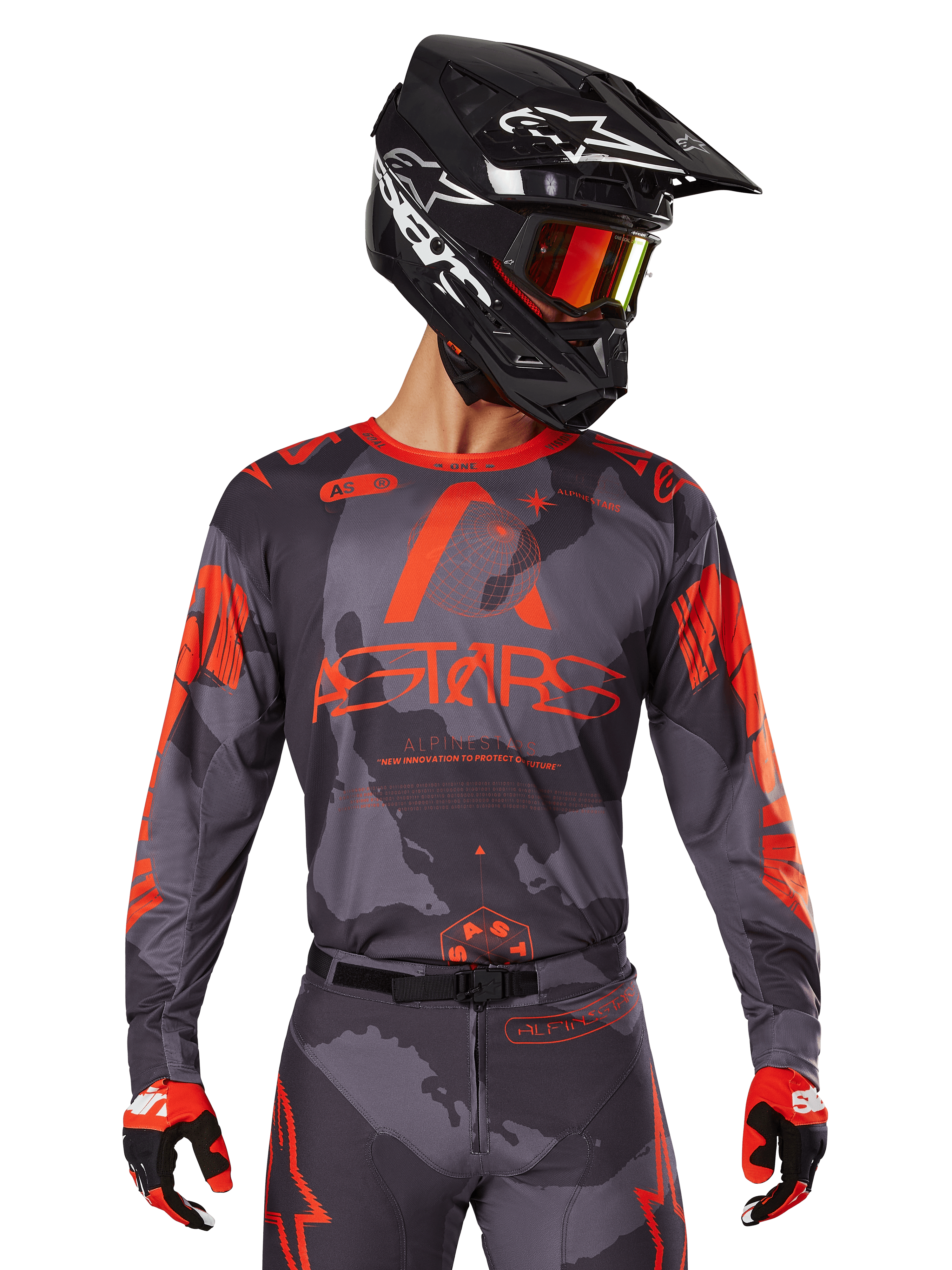 Alpinestars 2025 Racer Hollow Jersey, Motocross Jersey, Gray Camo and Orange Fluo, worn with matching gear set including pants and gloves, featuring a black helmet with white graphics and goggles, bold ASTARS branding, protective off-road racing sportswear
