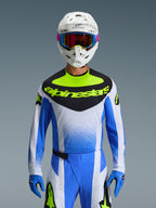 Alpinestars 2026 Techstar Knif Gear Set, Motocross rider wearing blue, white, and neon yellow racing gear, jersey with a black chest panel and neon yellow branding, white helmet with multi-colored goggles, matching blue gloves and pants, high-performance athletic racing outfit for off-road competition