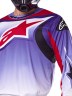 Maillot Alpinestars Fluid Wurx 2025, maillot de motocross, violet et rouge vif, gros plan d'un pilote portant le maillot avec un grand logo étoile Alpinestars rouge sur la poitrine, accents graphiques incurvés noirs et rouges, coupe athlétique pour la course tout-terrain
