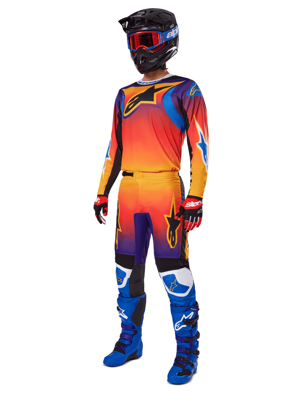2025 Fluid Wurx Gear Set, Motocross Jersey and Pants with Orange Red Purple gradient and Blue Yellow star designs, worn with a Black helmet, red goggles, Red and Black gloves, and Blue boots, high-visibility racing gear
