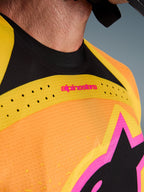 Alpinestars 2026 Techstar Nomur Jersey, maillot de motocross, orange, jaune et rose, gros plan sur la poitrine et le col, avec perforations laser, logo rose et tissu en maille respirante