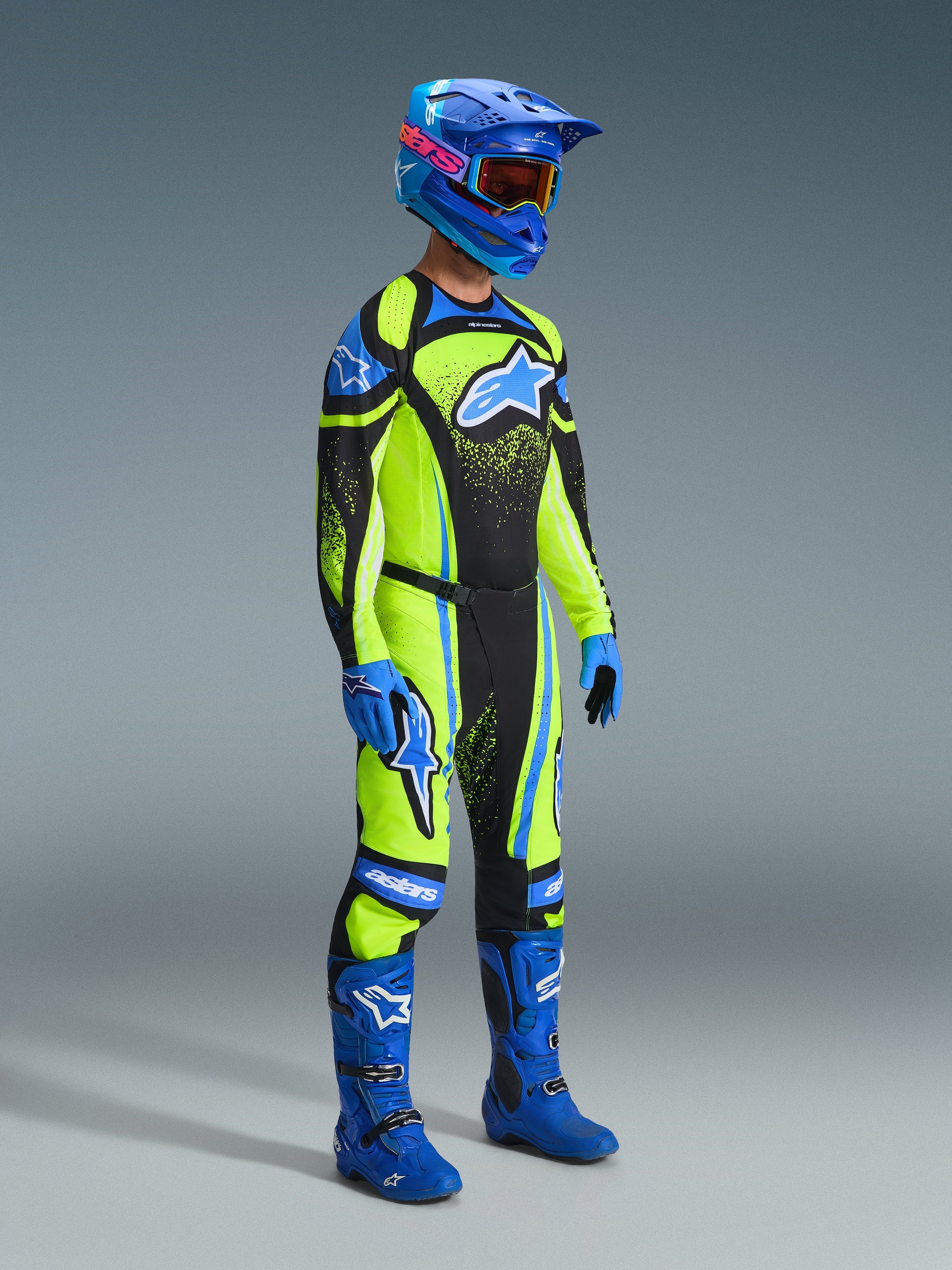 Motocross rider wearing complete racing gear, 2026 Techstar Nomur Jersey in Dark Navy and Yellow Fluo, matching pants, blue helmet with goggles, blue boots and gloves, coordinated outfit for off-road racing