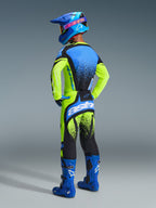 Motocross rider wearing the Alpinestars 2026 Techstar Nomur Gear Set, yellow fluo and dark navy jersey with blue accents, matching yellow and black pants with large 'astars' branding, blue helmet with pink accents and blue goggles, bright blue boots, coordinated high-performance motocross outfit