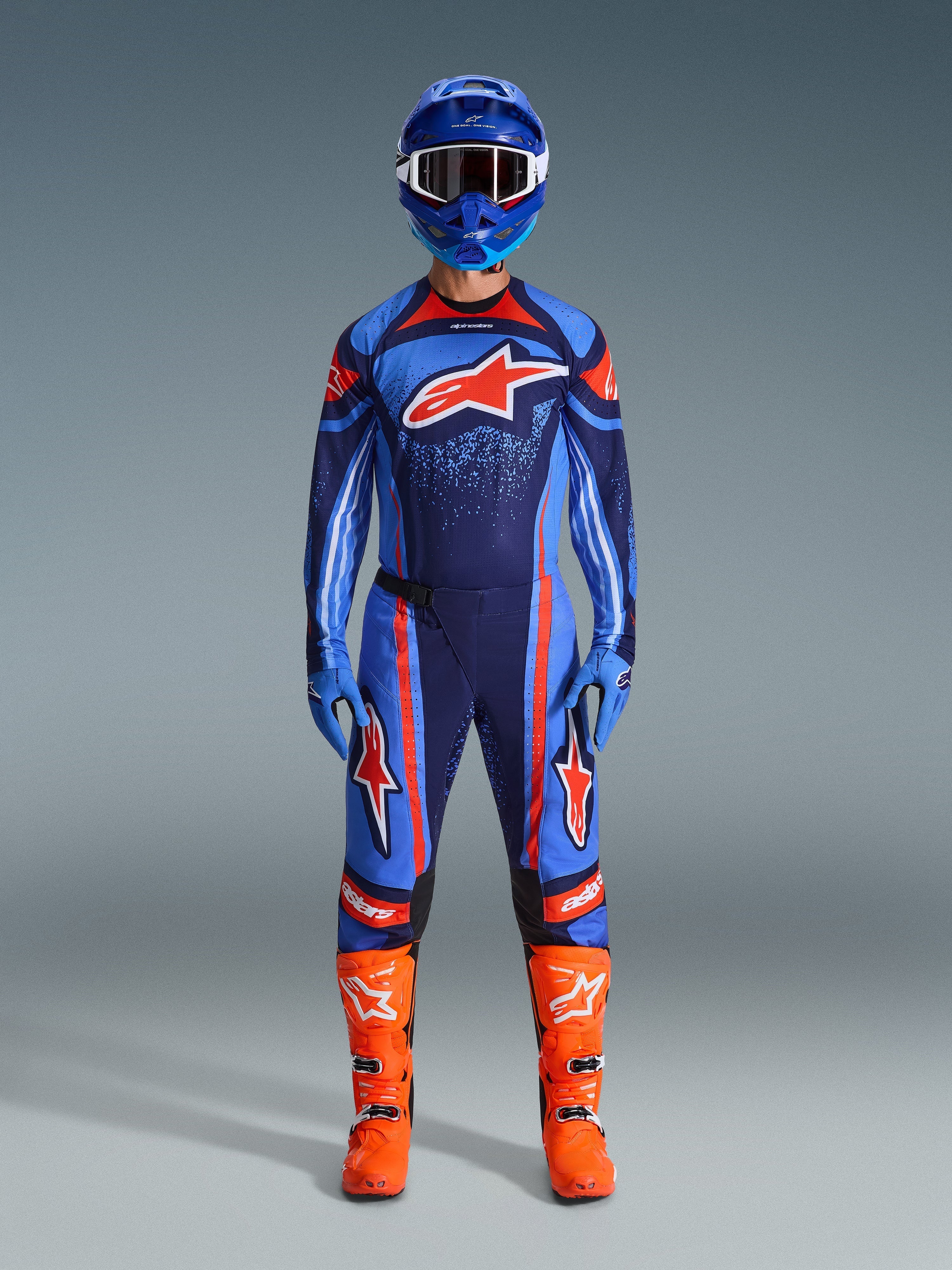 Set d'équipement Alpinestars Techstar Nomur 2026, équipement de motocross, bleu marine, orange et bleu UCLA, tenue de pilotage complète avec casque bleu, maillot et pantalon assortis, gants bleus et bottes orange vif, logos étoile, protection tout-terrain haute performance