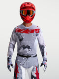 Maillot Racer Air Lone Alpinestars, maillot de motocross homme, gris camouflage et rouge, respirant, porté par un pilote.