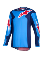 Maillot Alpinestars Fluid Grid 2026, maillot de motocross, bleu et rouge, avec de grands logos en étoile Alpinestars rouges, panneaux latéraux bleu foncé, construction en poly-tissu léger avec un panneau arrière allongé pour la conduite tout-terrain.