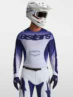 Alpinestars Maillot Racer Air Amber, maillot de motocross pour homme, bleu et blanc, construction en mesh respirant pour une performance tout-terrain, porté par un pilote avec casque et gants