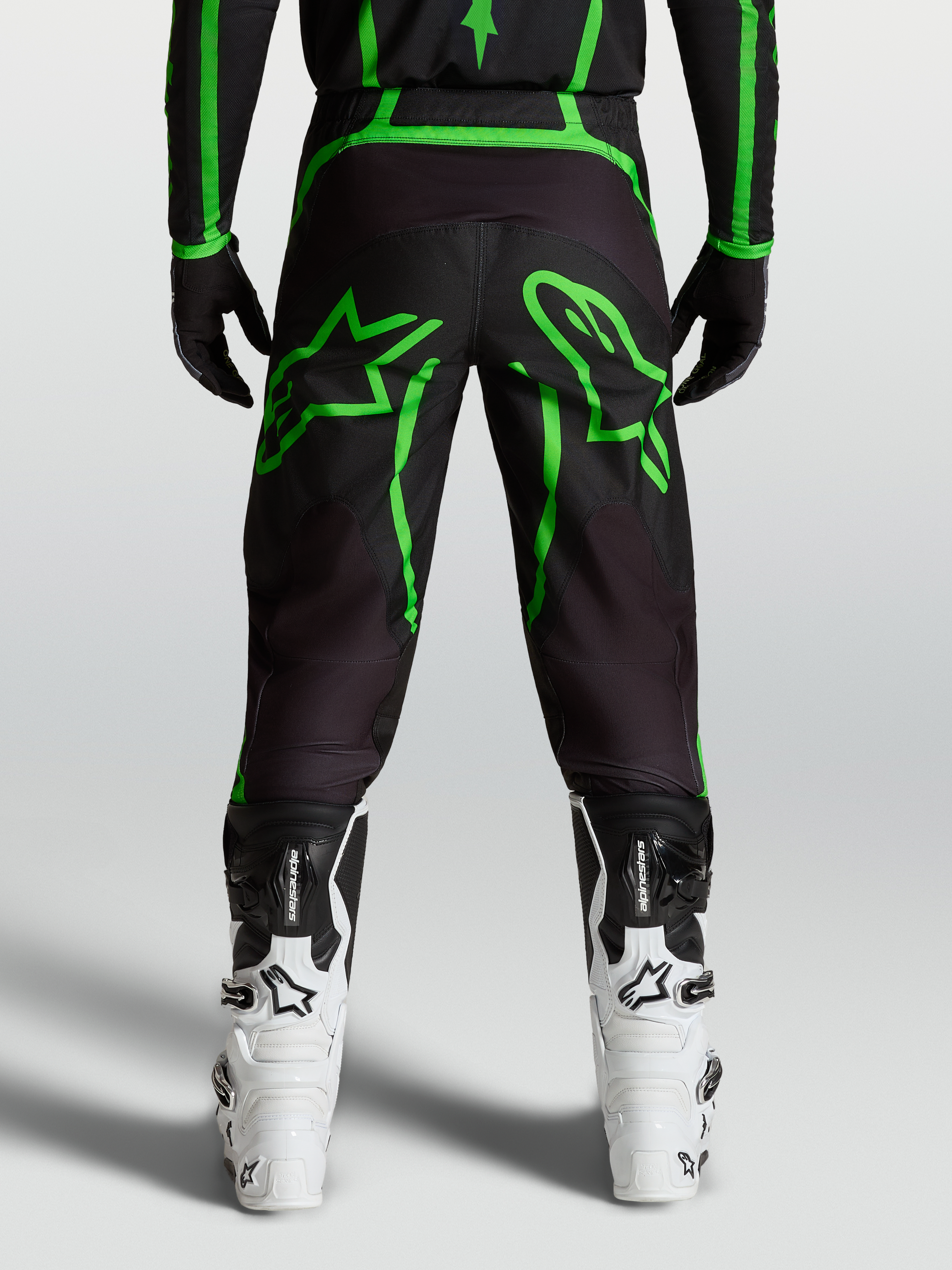 Alpinestars Fluid Apex V2 Pants, Men's Motocross Pants in Black and Fluo Green with large star graphics, rear view on-model.
