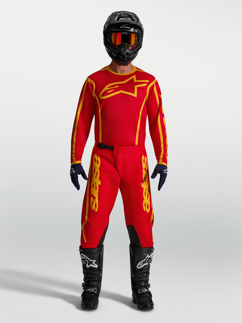 Alpinestars maillot Fluid Apex V2 et Fluid Apex V2 Gear Set, équipement de motocross pour homme, rouge et doré, tissu respirant, porté par un mannequin avec un kit complet.