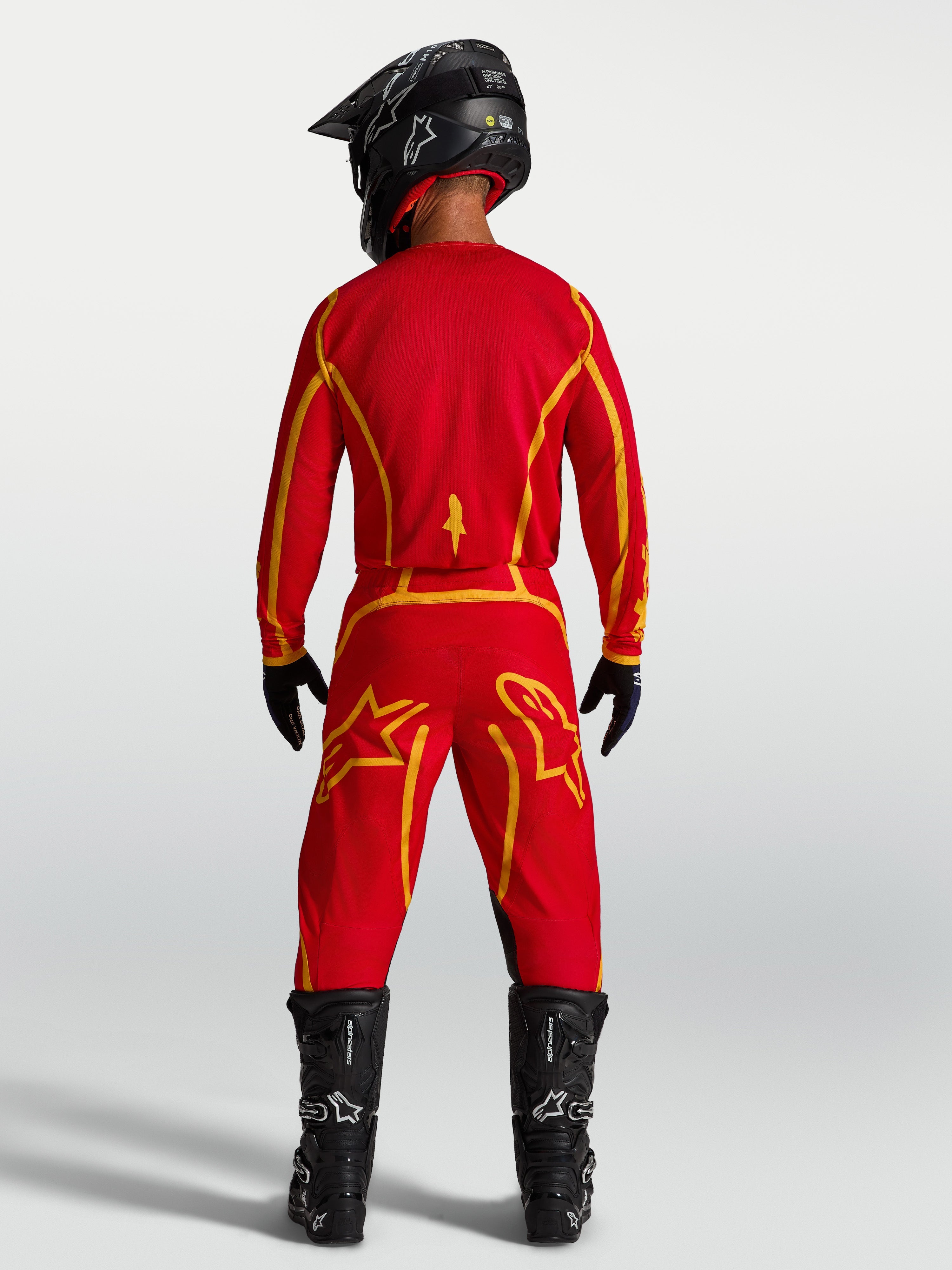 Alpinestars Fluid Apex V2, maillot de motocross pour homme, rouge et doré, textile respirant, vue de dos avec équipement.