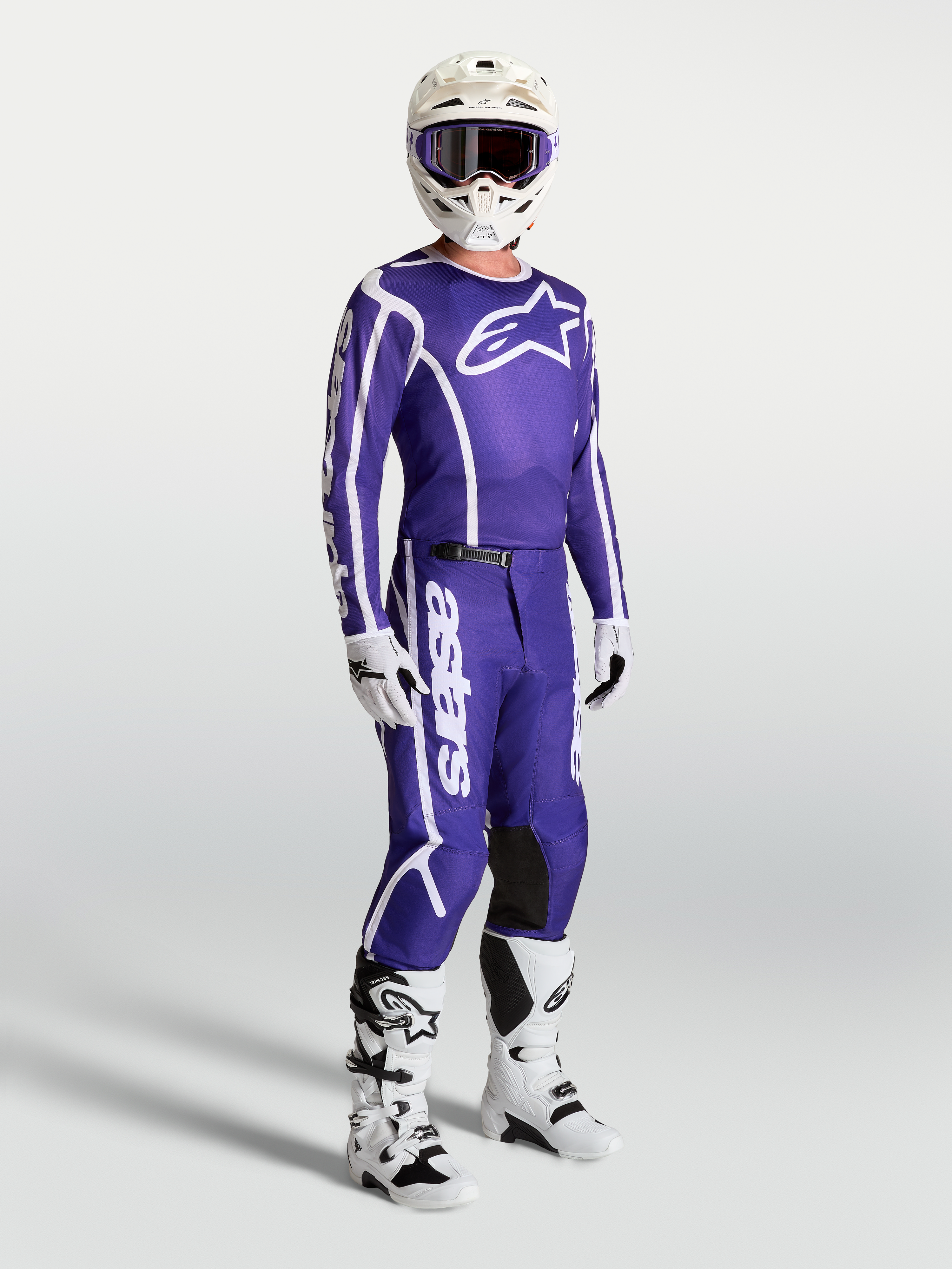 Maillot Alpinestars Fluid Apex V2 et pantalon de motocross pour homme, bleu foncé et blanc, portés avec bottes et casque