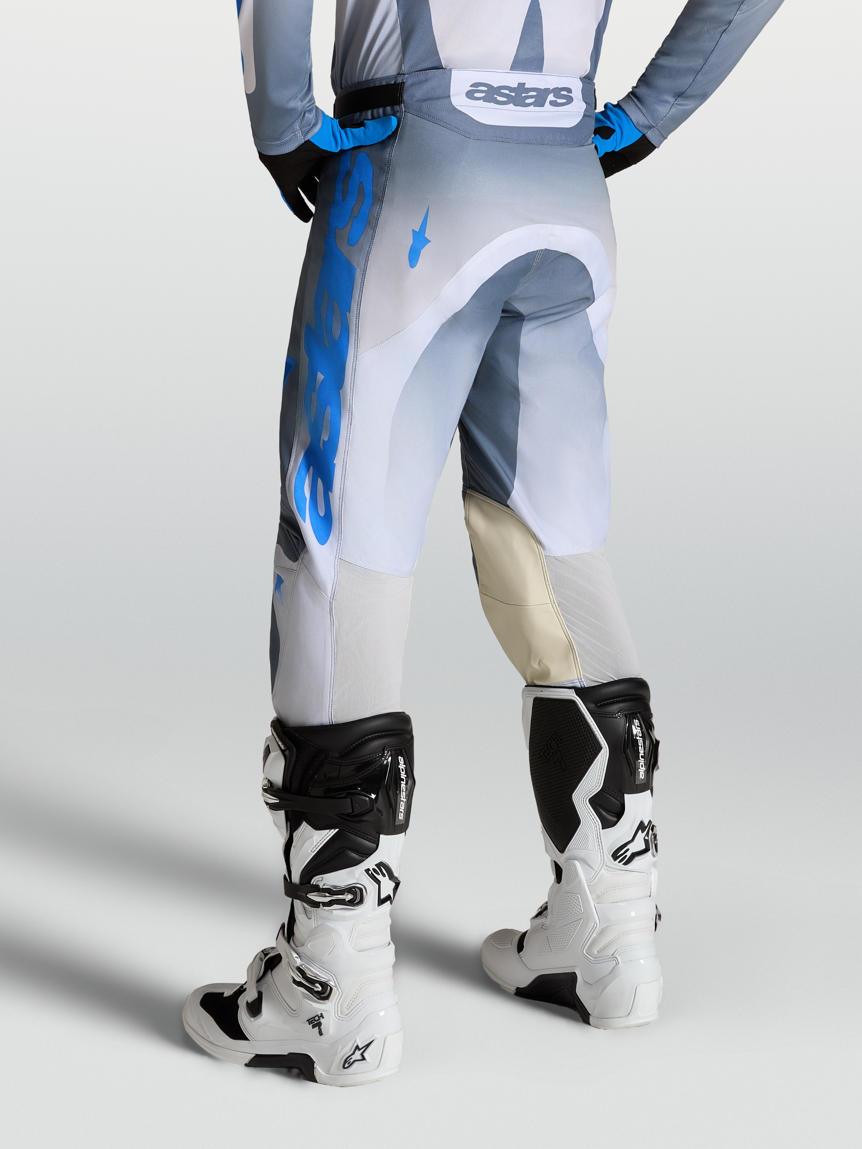 Alpinestars Pantalon Racer Amber, pantalon de motocross pour homme, gris et bleu, avec panneaux en cuir et ventilation arrière, vue de dos sur mannequin.