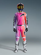 Tenue de motocross complète Alpinestars Racer Air Portl 2026, avec dégradé rose, violet et orange sur le pantalon et le maillot, casque assorti, lunettes jaunes, bottes blanches et gants noirs pour un look tout-terrain coordonné.