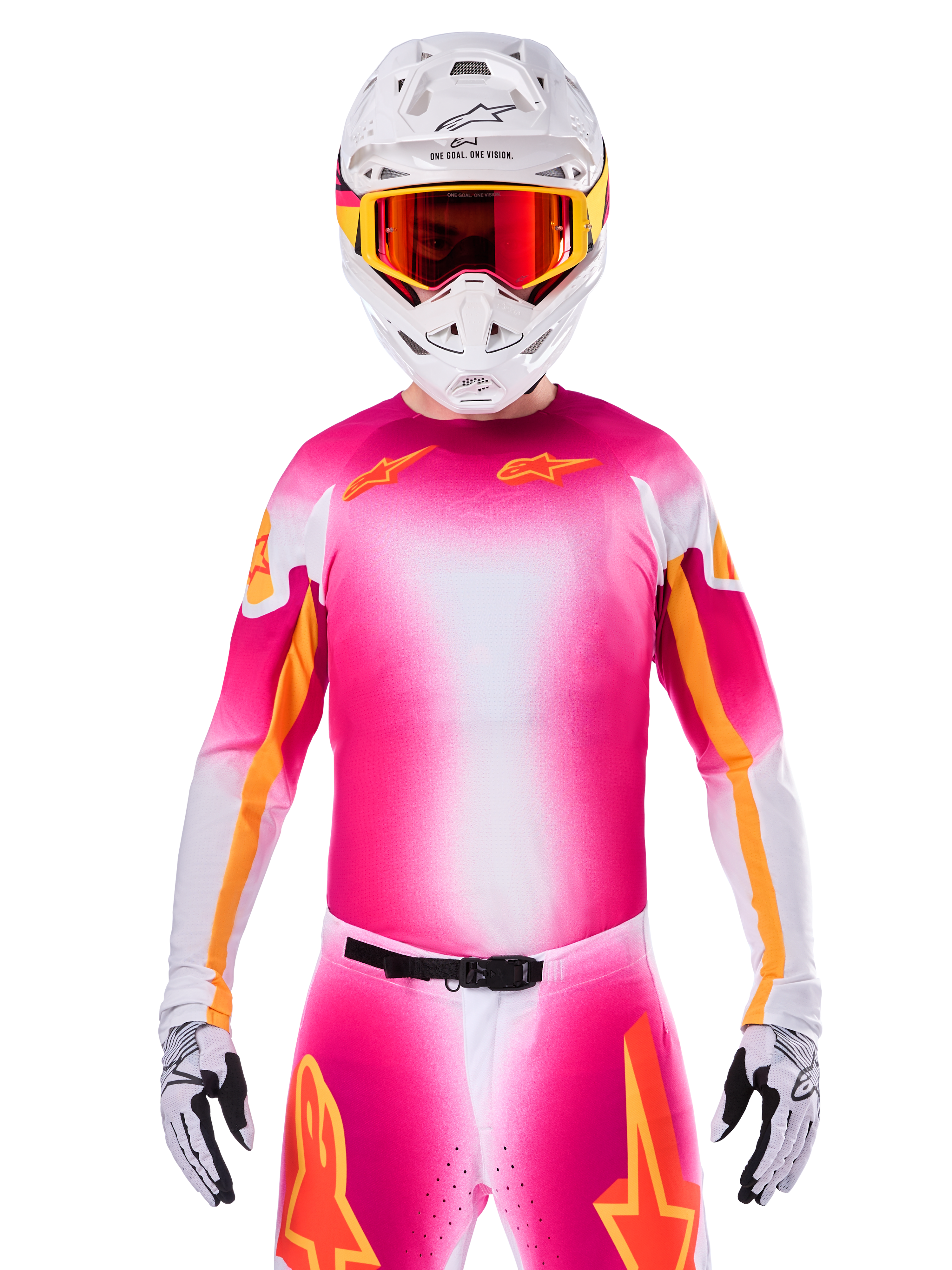 Alpinestars Limited Edition Supertech AFD MIG Jersey, maillot de motocross rose fluo et blanc, avec un dégradé éclatant et des logos d'étoiles orange, porté comme une tenue de course complète avec pantalon assorti, casque blanc et lunettes rouges, équipement professionnel pour le tout-terrain