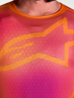 Maillot Alpinestars Fluid Kepler, maillot de motocross pour homme, violet et orange, gros plan sur le logo A-star orange.