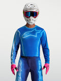 Alpinestars maillot Fluid Kepler, maillot de motocross pour homme, bleu et bleu clair, coupe ergonomique en poly-tissu léger, porté avec casque et gants roses, idéal pour le tout-terrain et l'enduro.