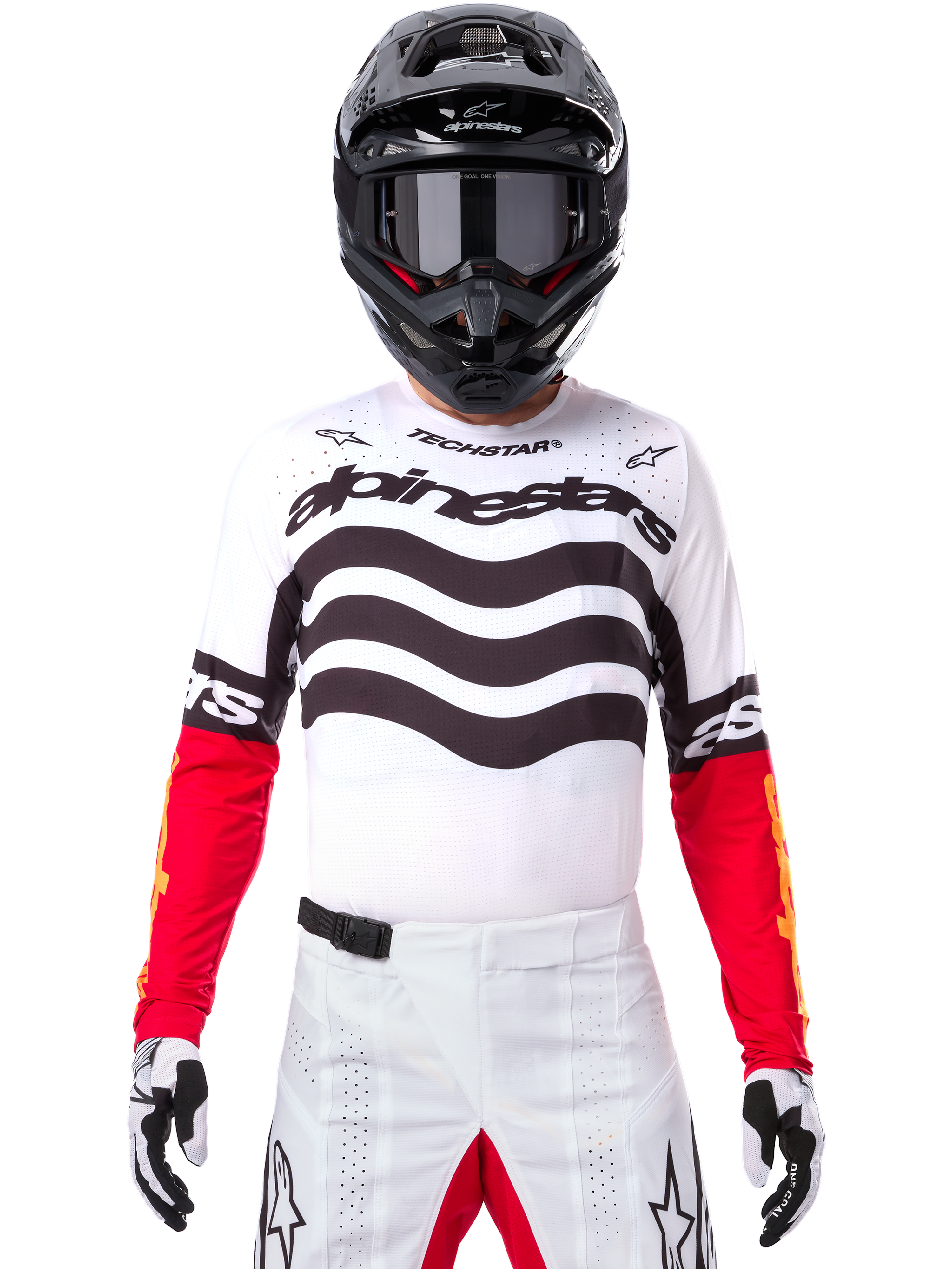 Motocross rider wearing complete racing gear, Limited Edition Techstar Deep Jersey in white and black with red sleeves, featuring wavy graphics and bold Alpinestars branding, white motocross pants, black helmet and goggles, coordinated outfit for off-road racing