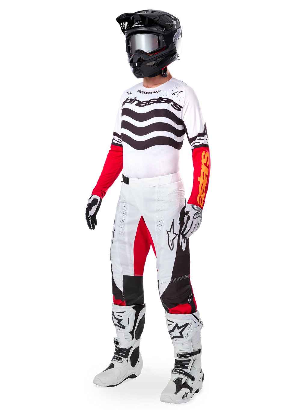 Pilote de motocross portant un équipement de course complet, Maillot Techstar Deep Limited Edition avec des rayures ondulées blanches et noires et des manches rouges, pantalon blanc et rouge assorti, casque noir, bottes blanches et noires, tenue coordonnée pour la course tout-terrain