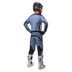 Pilote de motocross de dos portant le maillot Alpinestars 2024 Fluid Lurv et le pantalon assorti bleu clair et noir, avec logos noirs sur le dos et les manches, associé à un casque noir et des bottes blanches.