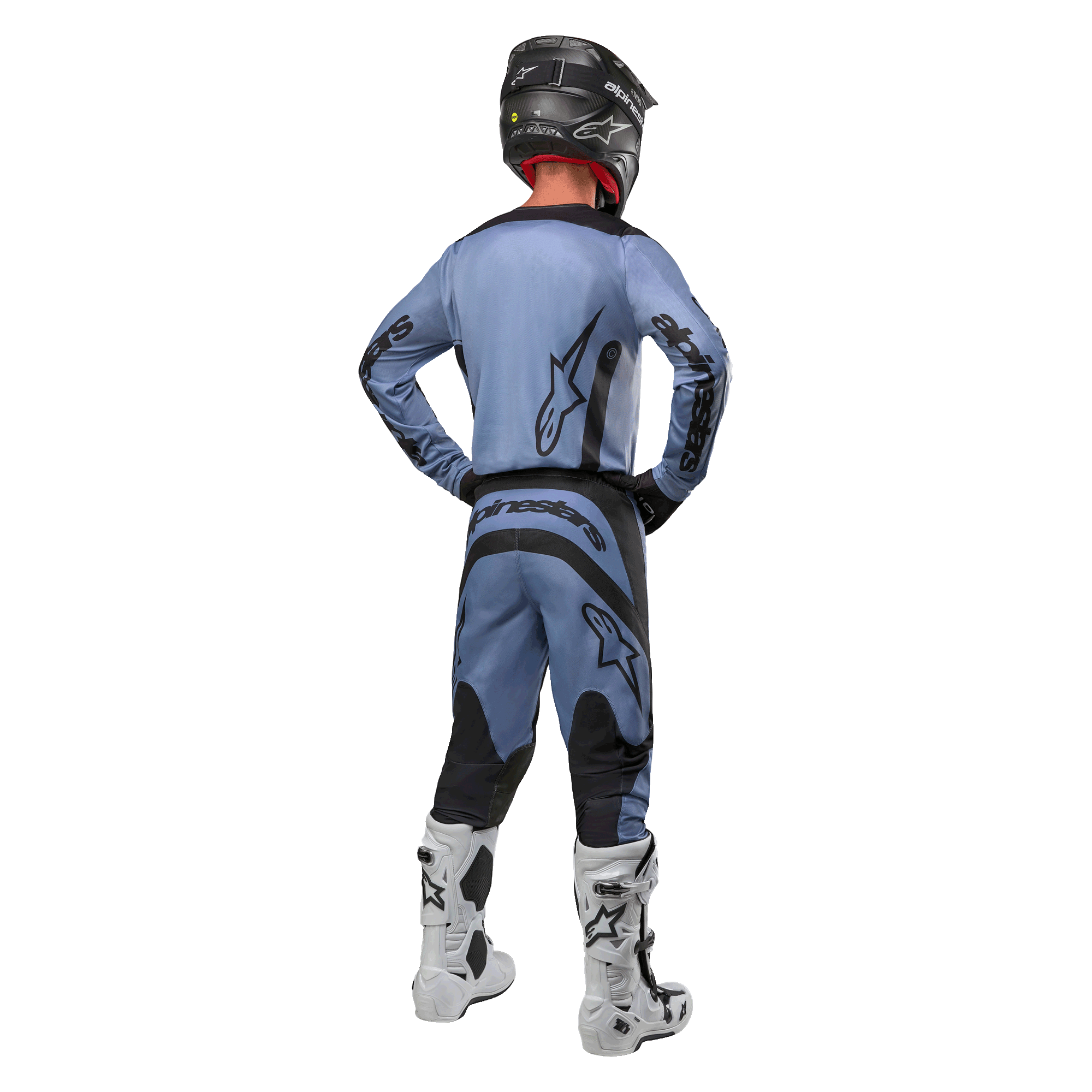 Pilote de motocross de dos portant le maillot Alpinestars 2024 Fluid Lurv et le pantalon assorti bleu clair et noir, avec logos noirs sur le dos et les manches, associé à un casque noir et des bottes blanches.