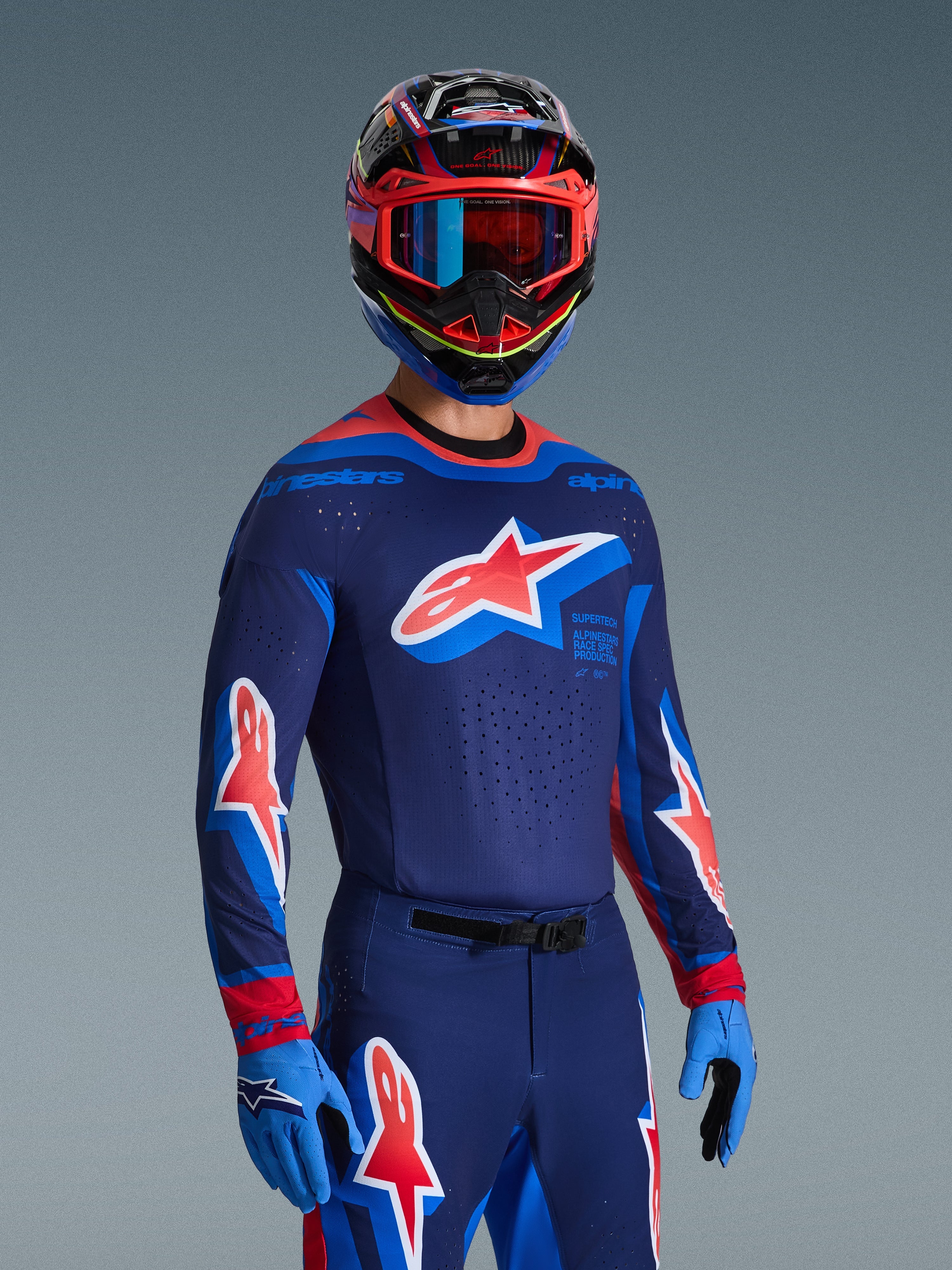 Ensemble d'équipement Alpinestars Supertech Vista 2026, pilote de motocross portant un maillot bleu foncé avec des accents bleu clair et rouges et un grand logo étoile sur la poitrine, pantalon et gants assortis, casque multicolore avec lunettes bleues et rouges, tenue de course de niveau professionnel