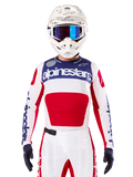 Maillot Techstar Fortitude Édition Limitée, maillot de motocross, blanc, rouge et bleu, porté avec pantalon et casque assortis, logo Alpinestars et devise « One Goal One Vision », détails perforés, design épuré pour la performance tout-terrain