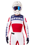 Maillot Techstar Fortitude Édition Limitée, maillot de motocross, blanc, rouge et bleu, porté avec pantalon et casque assortis, logo Alpinestars et devise « One Goal One Vision », détails perforés, design épuré pour la performance tout-terrain