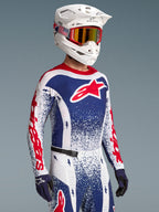 Maillot Alpinestars Techstar Unity, maillot de motocross édition limitée pour homme, bleu, blanc et rouge à motif éclaboussures, porté par un pilote