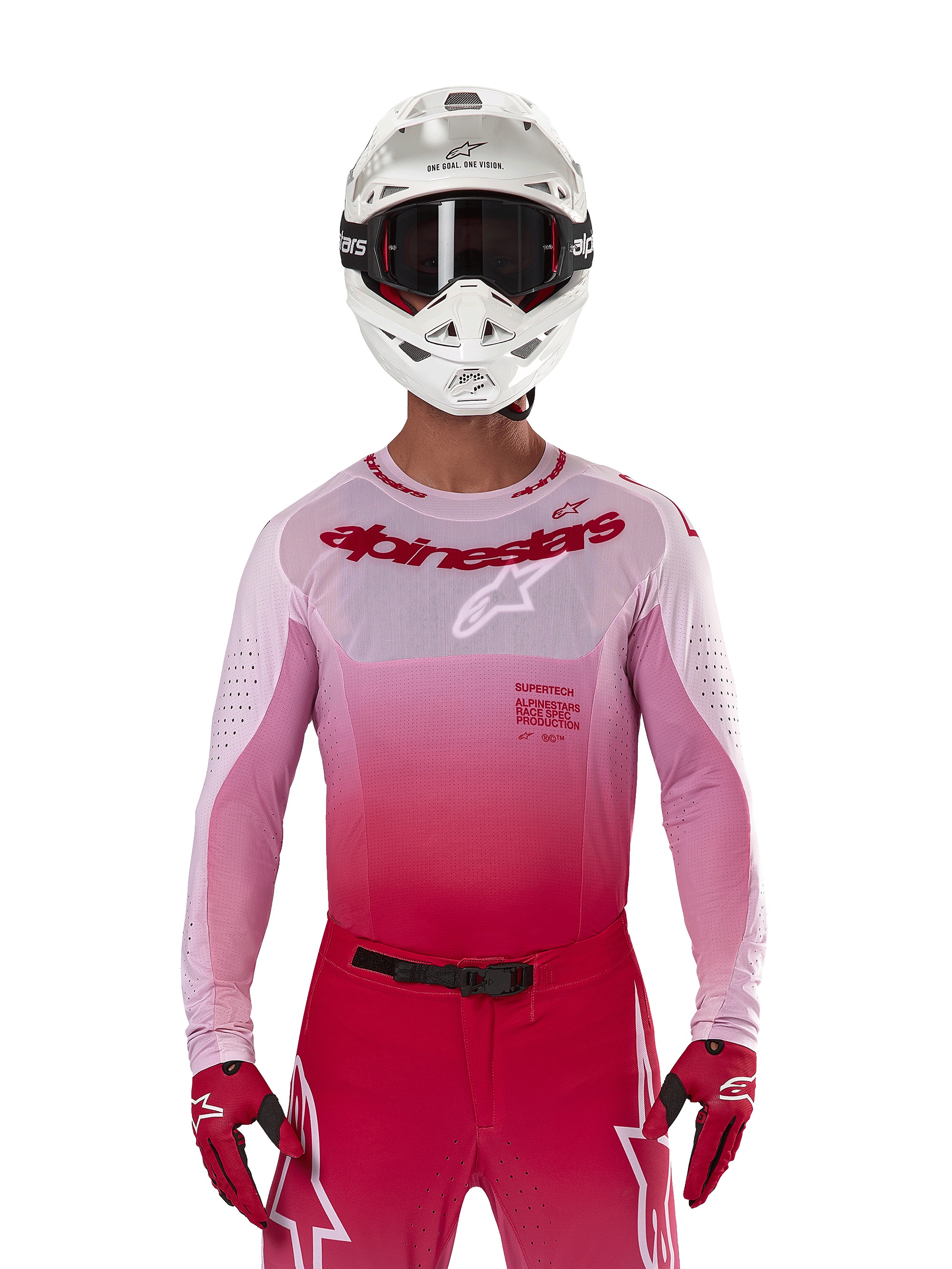 Pilote de motocross portant le maillot Alpinestars Supertech Dade 2024 en Red Berry Lilac, pantalon assorti, casque blanc avec lunettes noires et gants rouges, tenue de course professionnelle coordonnée avec des tons dégradés de rose et de rouge