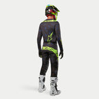 Alpinestars 2024 Techstar Rantera Jersey, Motocross Jersey, Black Navy Yellow Fluo, worn with matching pants, white and black boots, and a fluo yellow helmet, viewed from the back in complete off-road racing gear