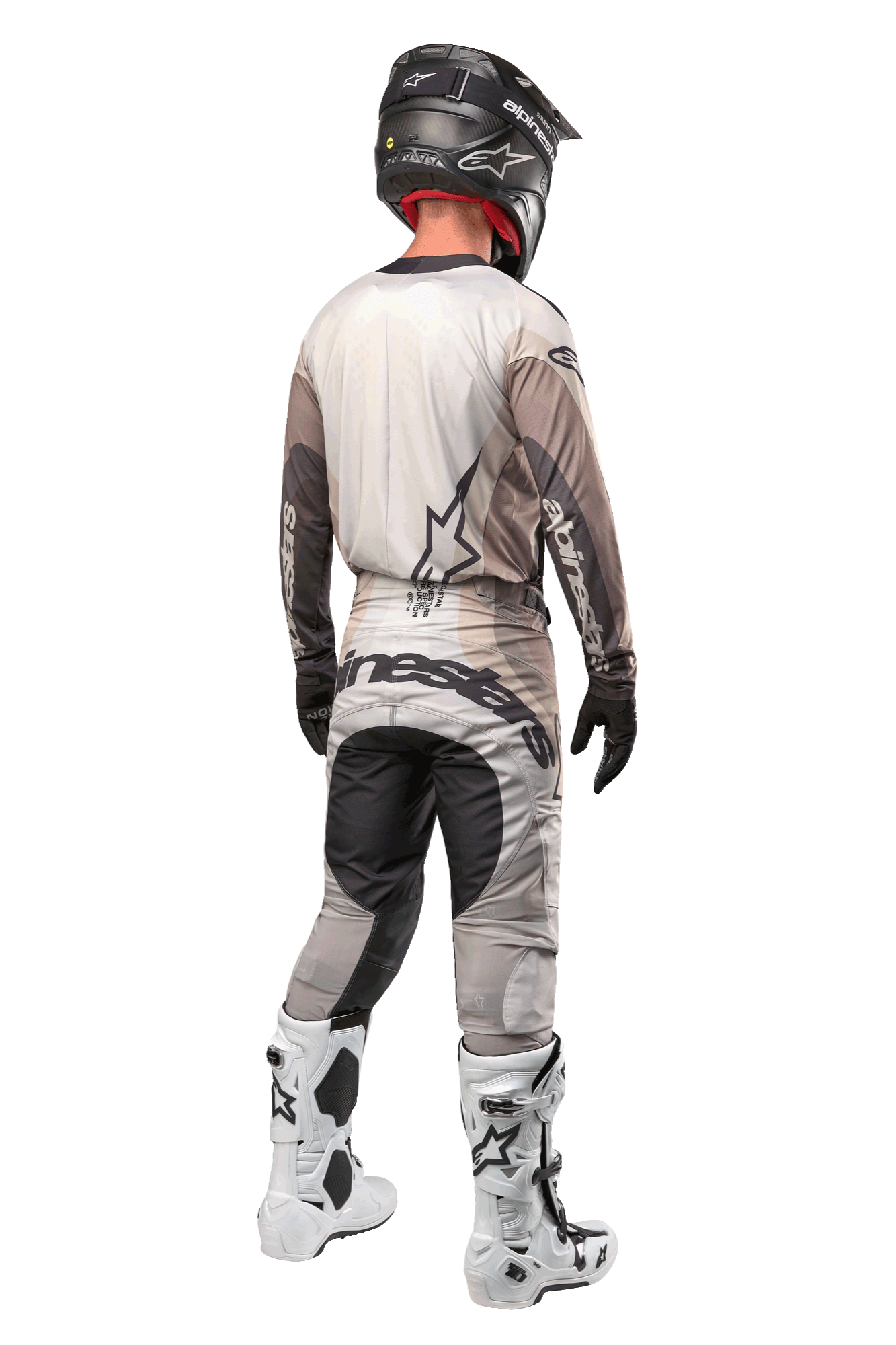 Pilote de motocross vu de dos portant le maillot Techstar Pneuma 2024 en Dark Sand Iron Dust Gray, pantalon de motocross assorti avec un logo imposant, casque noir et bottes de course blanches, équipement tout-terrain professionnel coordonné.