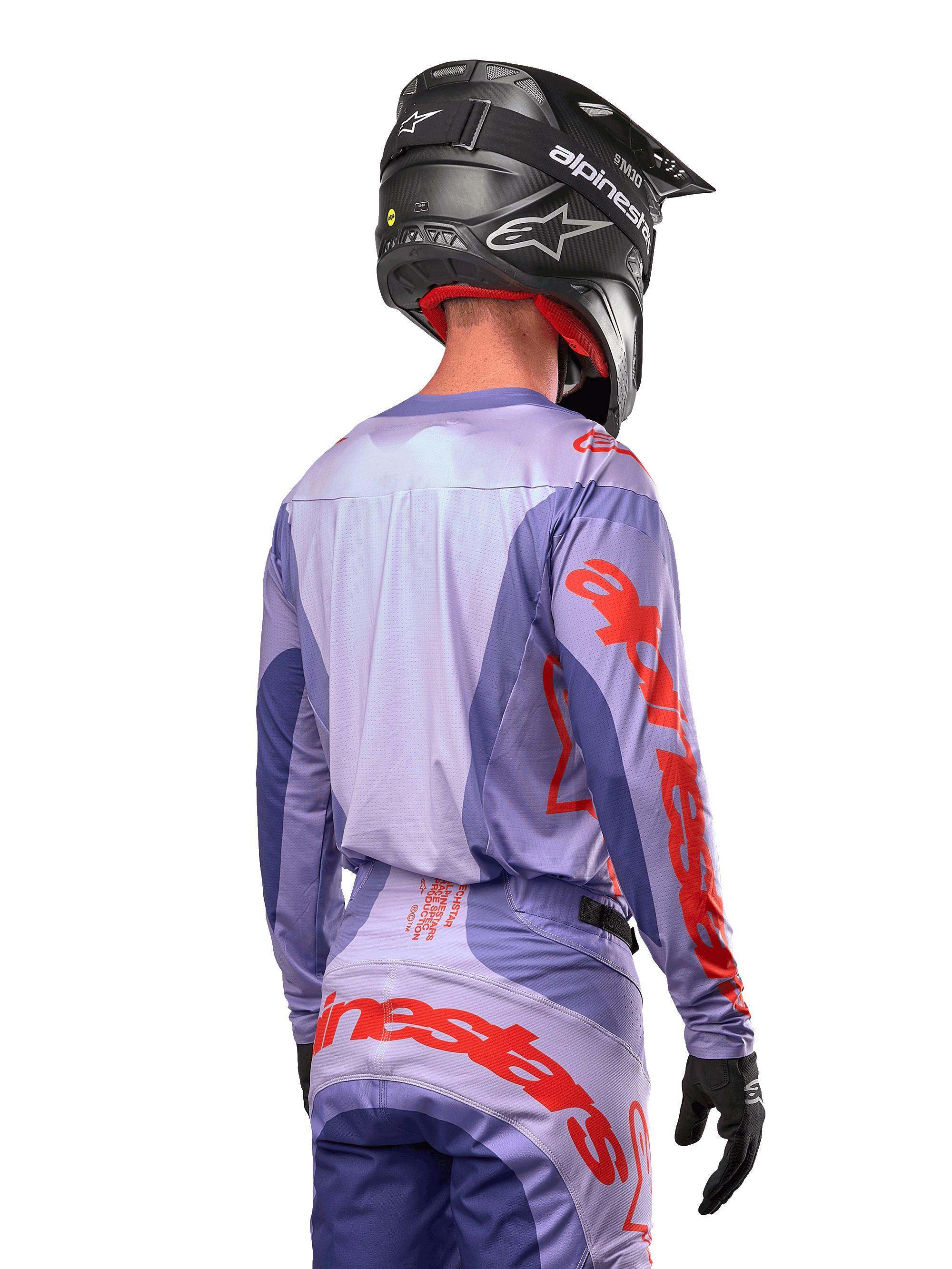 Maillot Alpinestars Techstar Ocuri 2024, maillot de motocross, pourpre et orange vif, vue arrière d'un pilote portant une tenue assortie et un casque noir, avec de grandes lettres Alpinestars orange sur les manches et le bas du dos