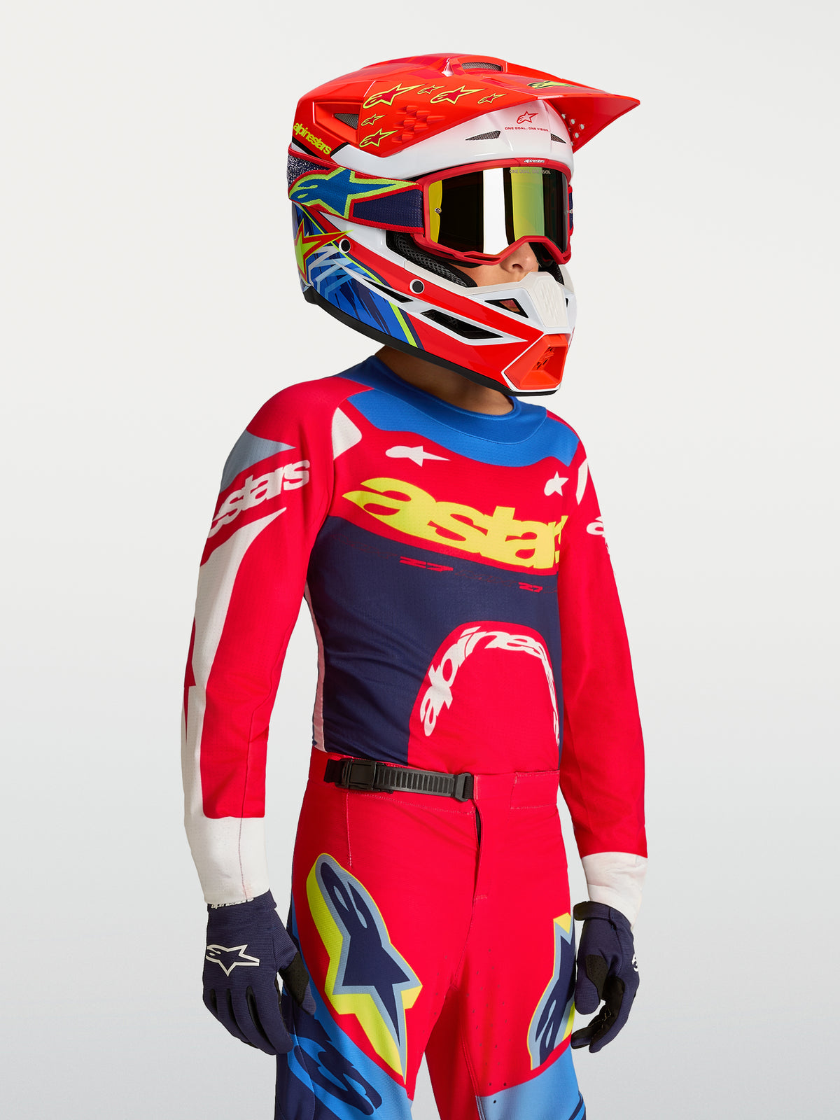 Maillot Supertech Dyna Junior Alpinestars, rouge et bleu marine, équipement de motocross en maille légère porté par un enfant.