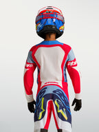 Maillot Supertech Dyna Junior 2027 d'Alpinestars, rouge et bleu marine, vue de dos sur un jeune pilote, maille extensible respirante pour le motocross