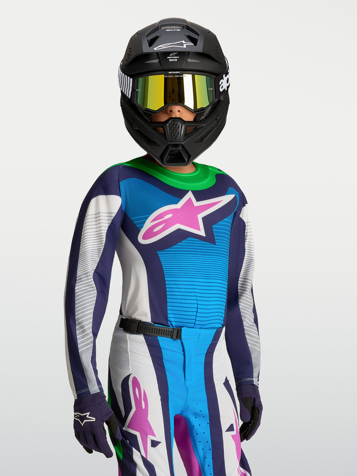 Maillot Alpinestars Supertech Maven Junior, maillot de motocross bleu, blanc et rose, coupe athlétique sur un jeune pilote.