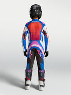 Ensemble Alpinestars Supertech Maven Junior, maillot et pantalon de motocross bleus et corail vif, vue de dos.