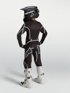 Alpinestars 2027 Fluid Apex V2 Junior, ensemble de motocross noir et argenté, vue de dos avec bottes blanches