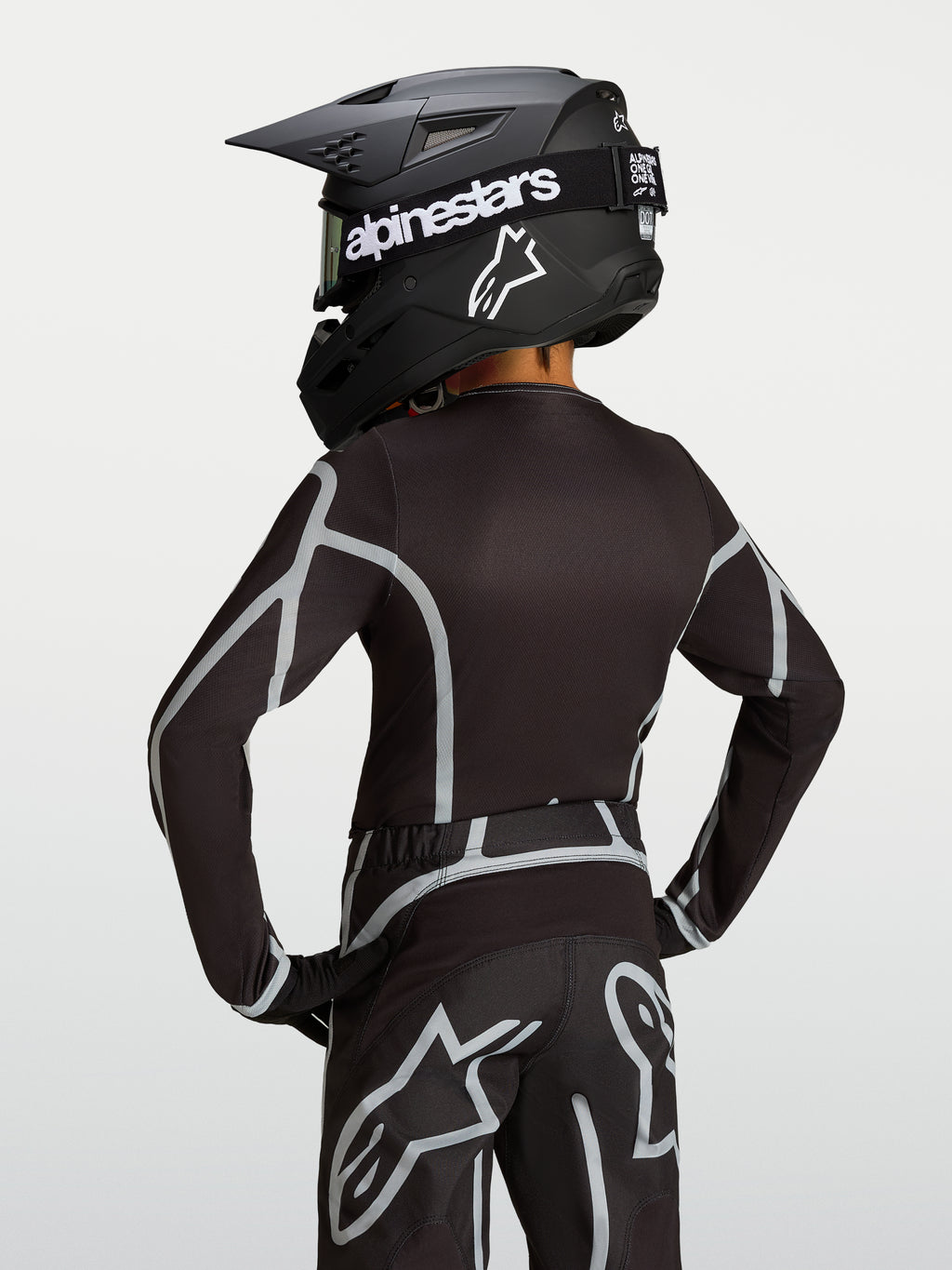 Maillot Alpinestars Fluid Apex V2 Junior, maillot de motocross pour enfant, noir et argenté, vue de dos montrant la coupe ergonomique.