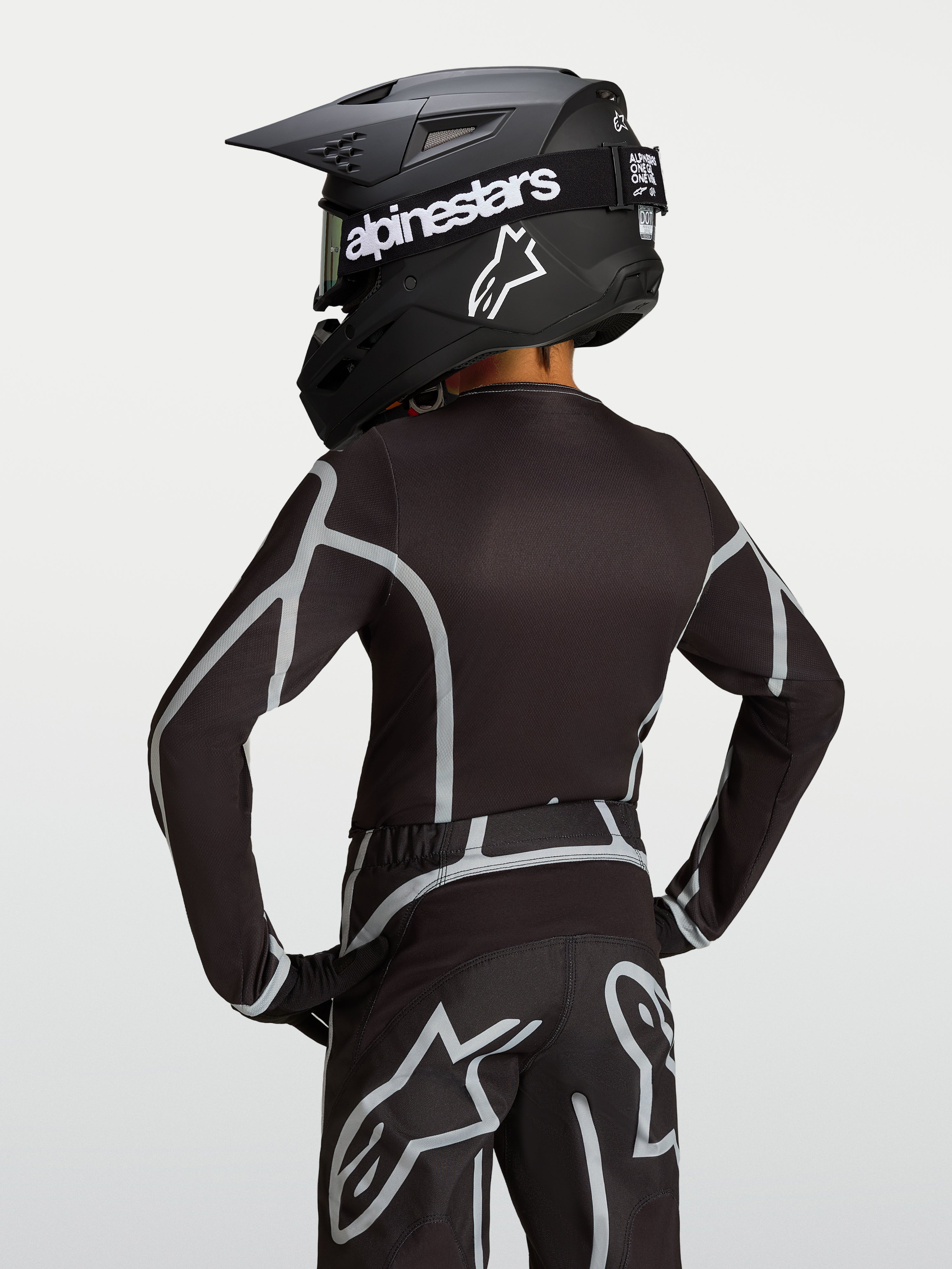 Maillot Alpinestars Fluid Apex V2 Junior, maillot de motocross pour enfant, noir et argenté, vue de dos montrant la coupe ergonomique.