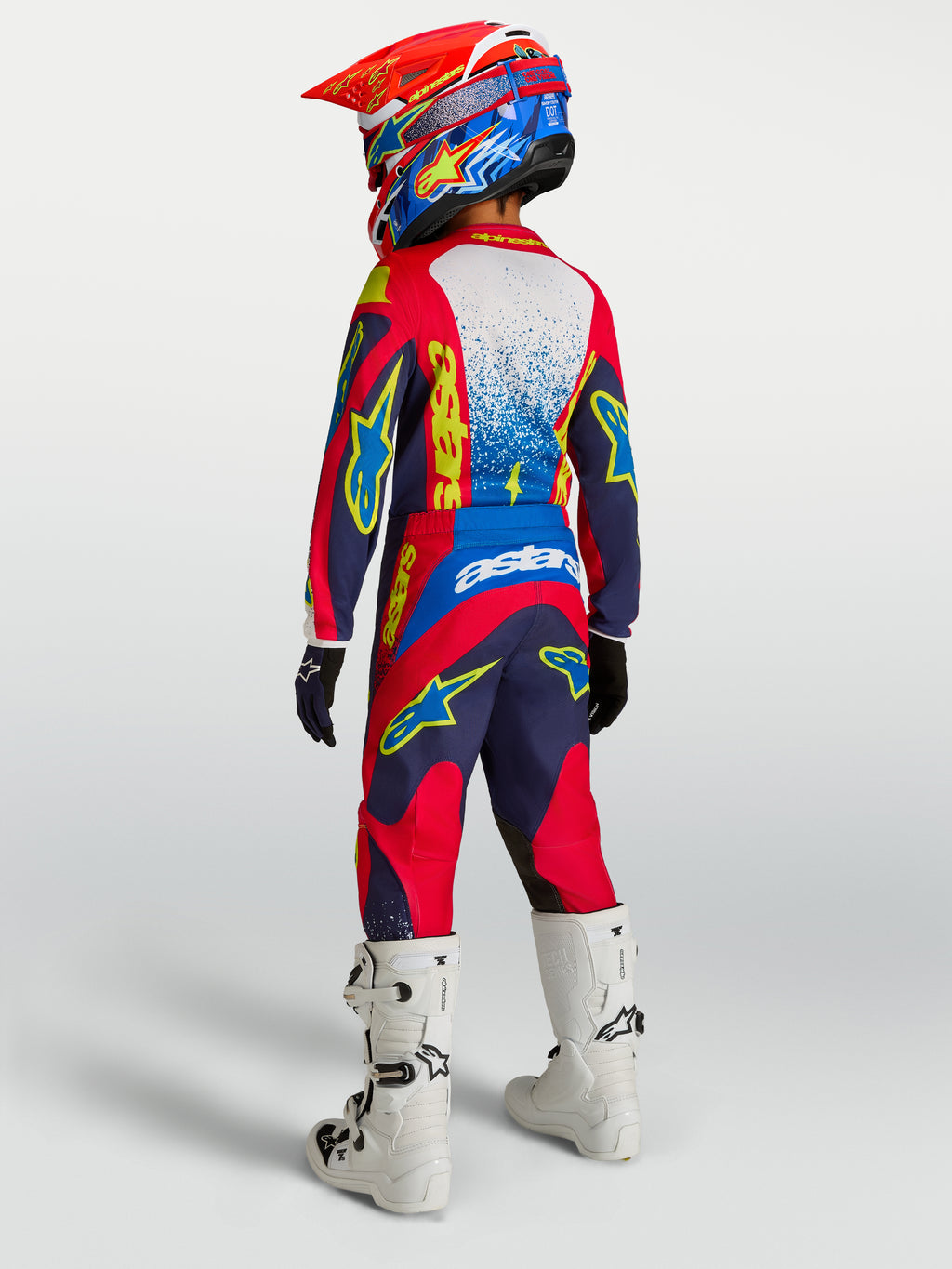 Ensemble Alpinestars Fluid Drag Junior 2027, tenue de motocross bleu marine et rouge, vue de dos avec bottes blanches