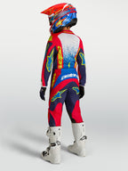 Ensemble Alpinestars Fluid Drag Junior 2027, tenue de motocross bleu marine et rouge, vue de dos avec bottes blanches