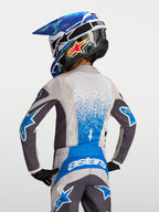 Maillot Alpinestars Fluid Drag Junior 2027, équipement de motocross gris et bleu pour enfant, vue de dos, textile respirant