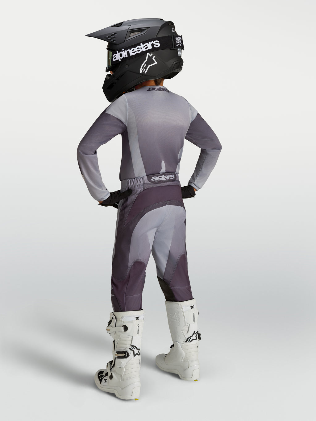 Alpinestars Ensemble Junior Fluid Amber, tenue de motocross grise et violette pour enfant avec casque et bottes blanches